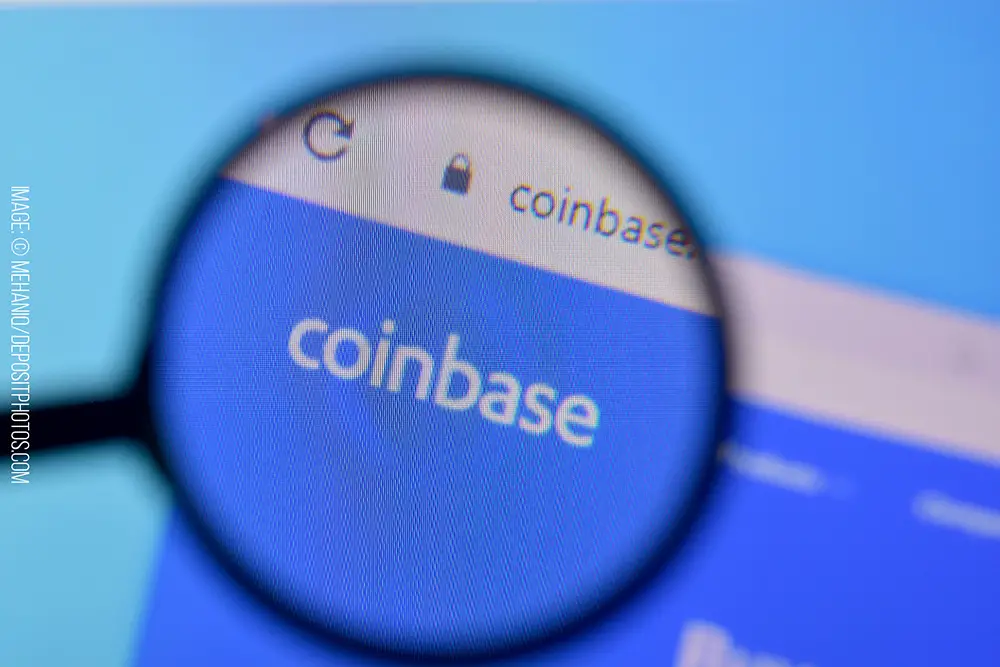 Coinbase open on a computer with a magnifying glass looking at the logo